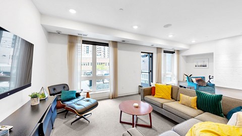 A living room with a blue couch and a yellow throw pillow.