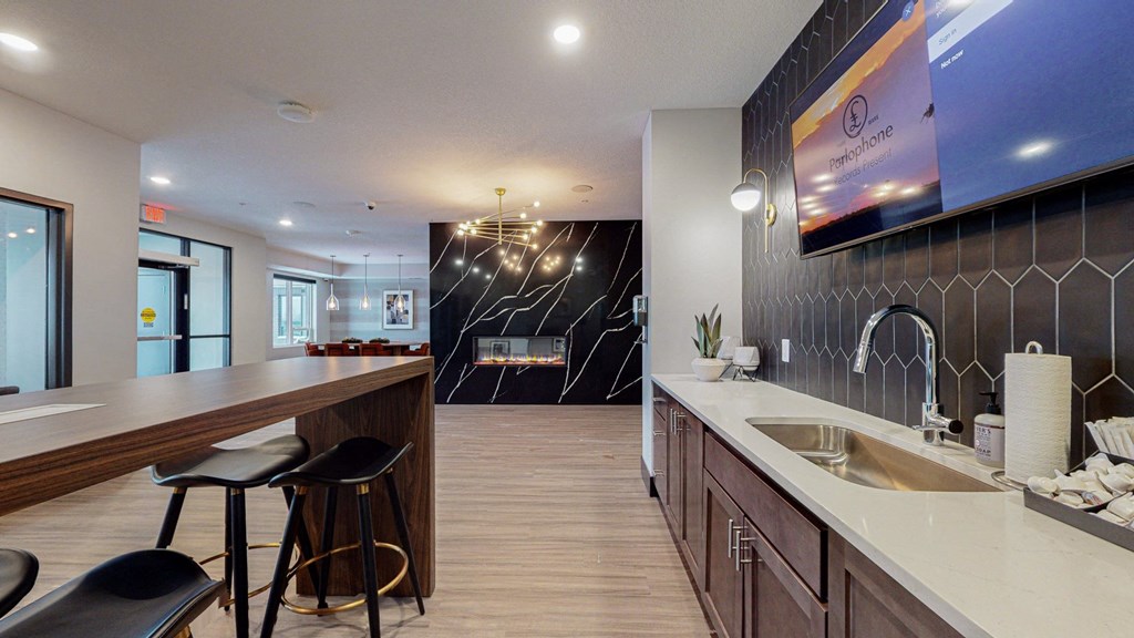 a kitchen with a long counter and stools in front of it at The Morrison, Rosemount Minnesota