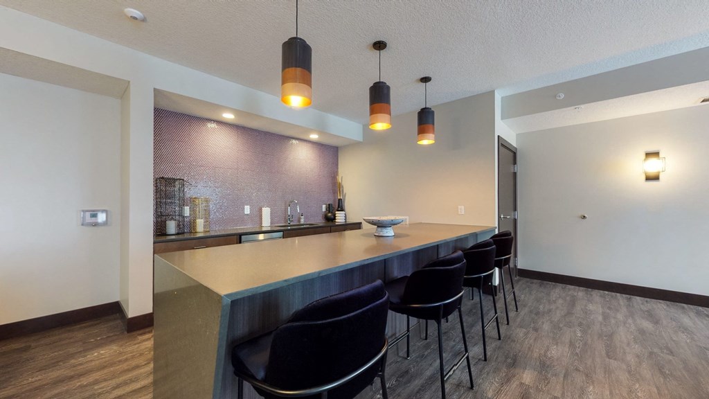 a kitchen with a long counter and a row of black chairs at The Morrison, Minnesota
