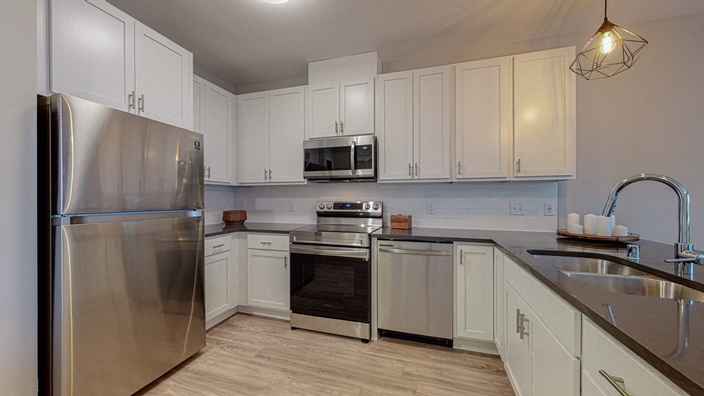 a kitchen with white cabinets and stainless steel appliances at The Morrison, Rosemount