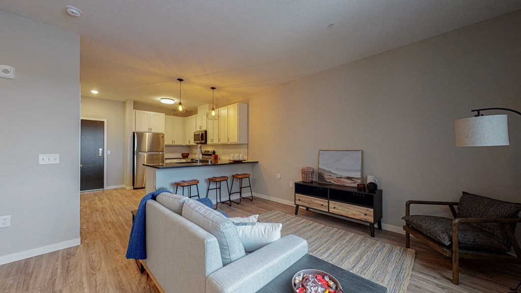 a living room with a kitchen in the background at The Morrison, Rosemount, 55068