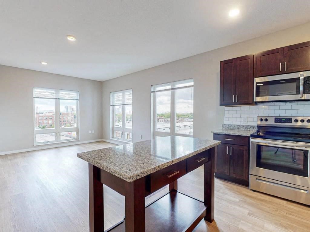 A kitchen with a granite countertop and stainless steel appliances.