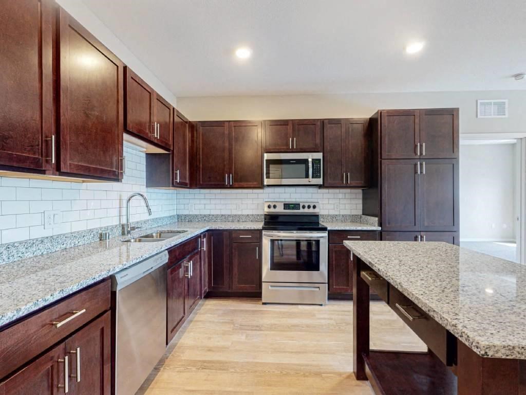 A kitchen with wooden cabinets and granite countertops.