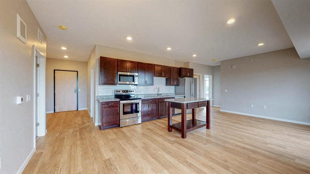 A kitchen with wooden floors and a center island.