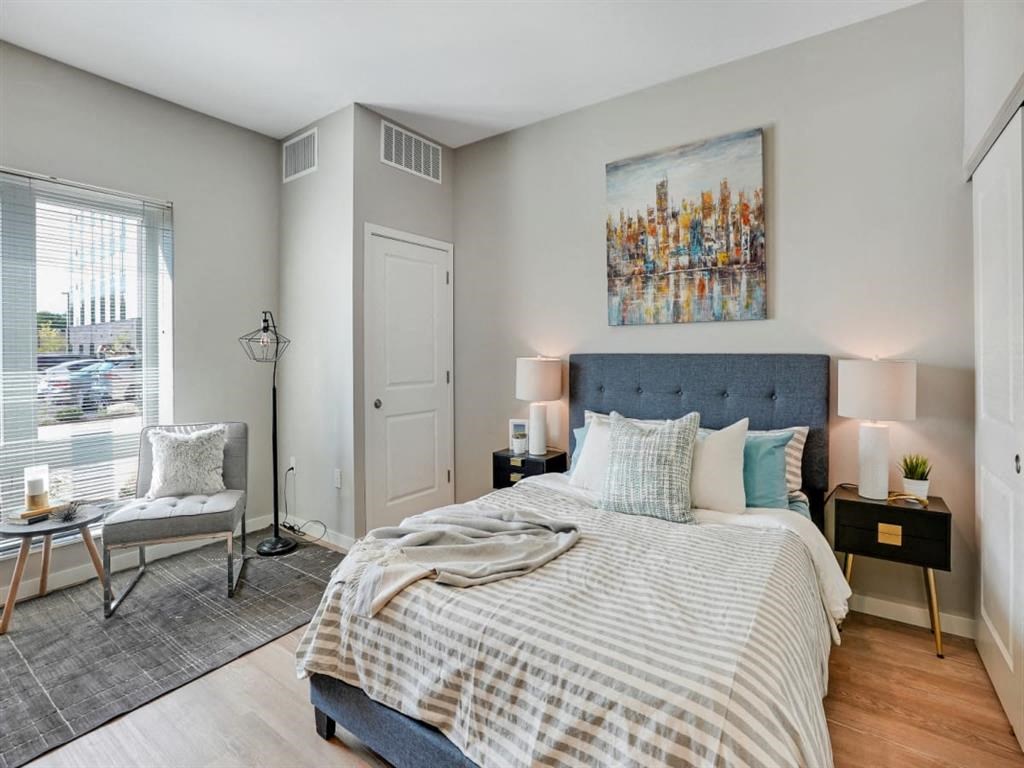 A bedroom with a large bed and a painting on the wall.