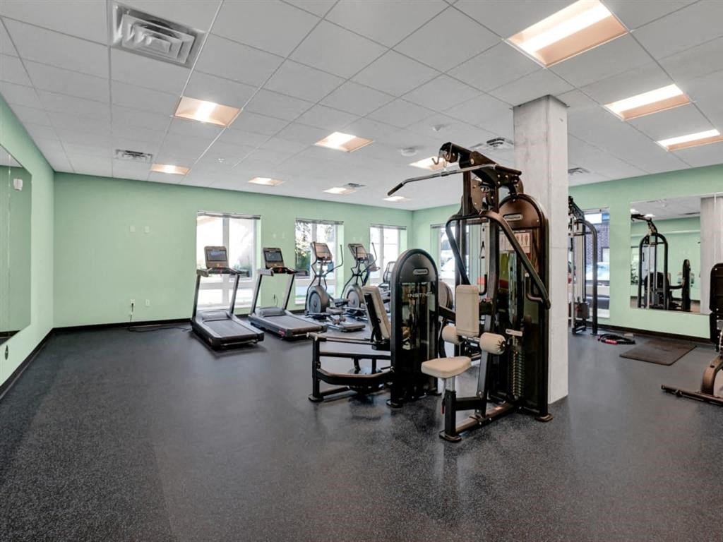 A gym with a variety of equipment including treadmills, weights, and exercise machines.