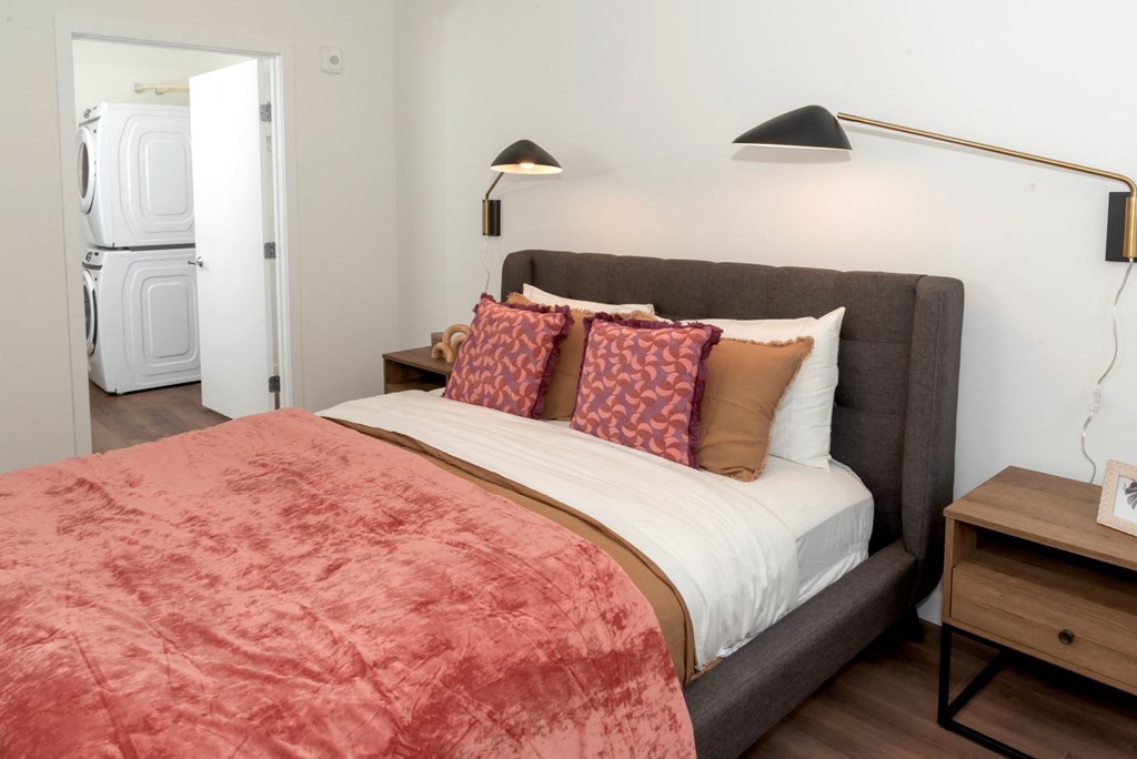 a bedroom with a bed and a washer and dryer