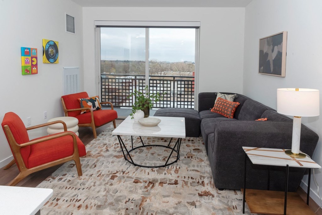 a living room with a large window and a couch and chairs