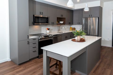 a kitchen with gray cabinets and a white counter top