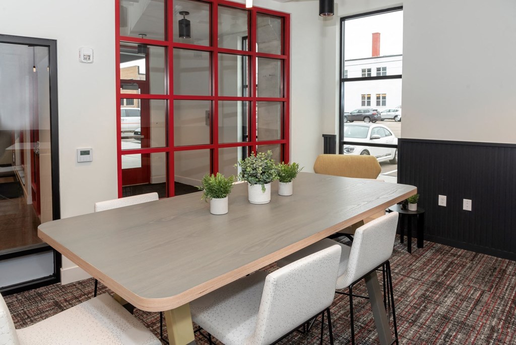 a dining room with a wooden table and white chairs