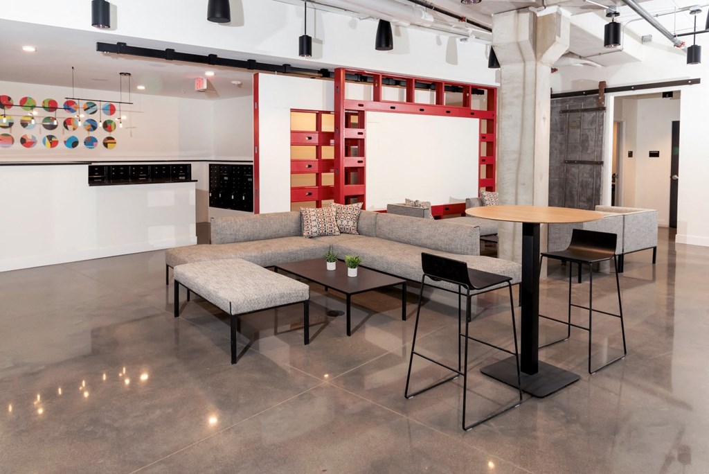 a living room with couches tables and chairs and a wall with artwork