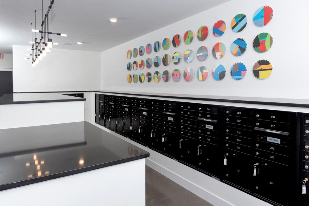 a wall of wine cabinets in a white room with a black counter top