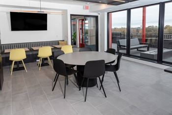 a meeting room with a table and chairs and a tv