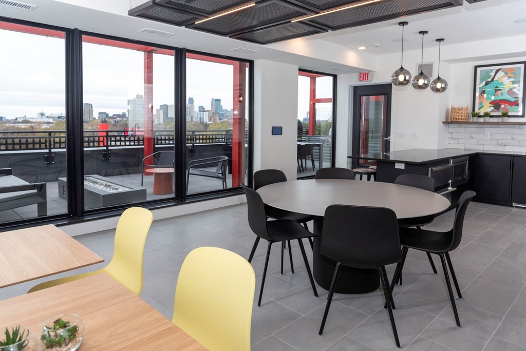a dining room with a table and chairs and a view of the city
