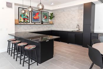 a kitchen with a black island and bar stools