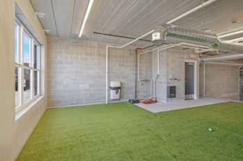 the yard is carpeted and has a soccer ball on the grass