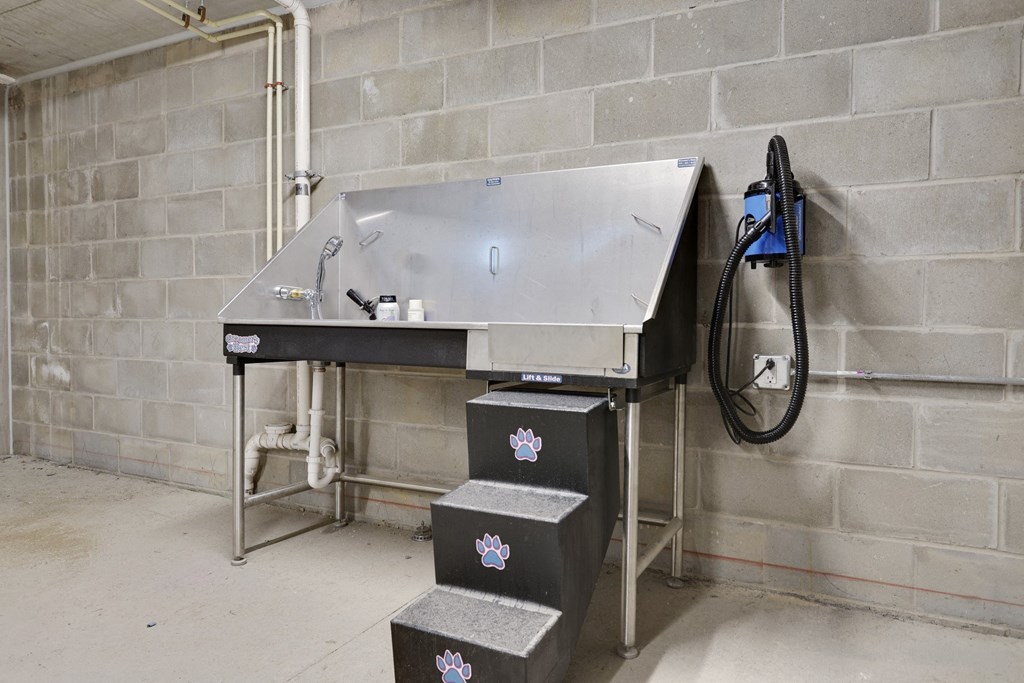 a large metal sink in a room next to a brick wall