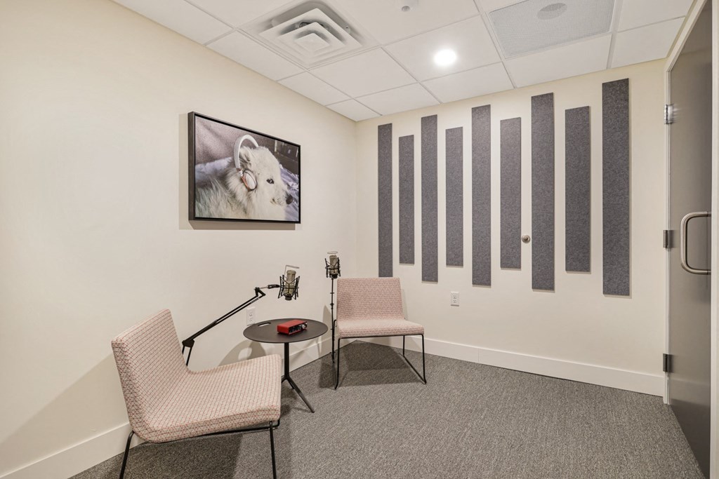 a room with two chairs and a table and a picture on the wall