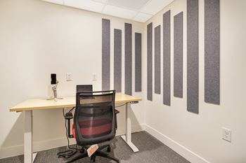 a room with a desk and a chair and a wall of stripes on the wall