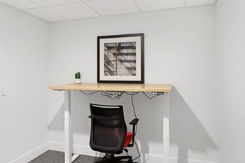a chair and a desk in a room with a picture