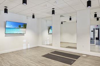 a yoga room with mirrors and a tv on the wall
