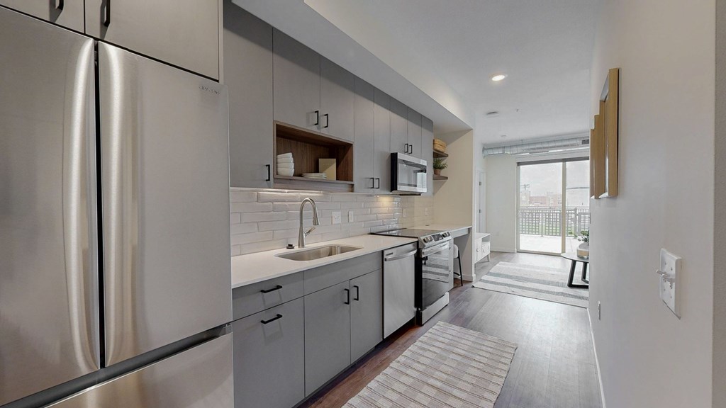 A modern kitchen with stainless steel appliances and white cabinetry.