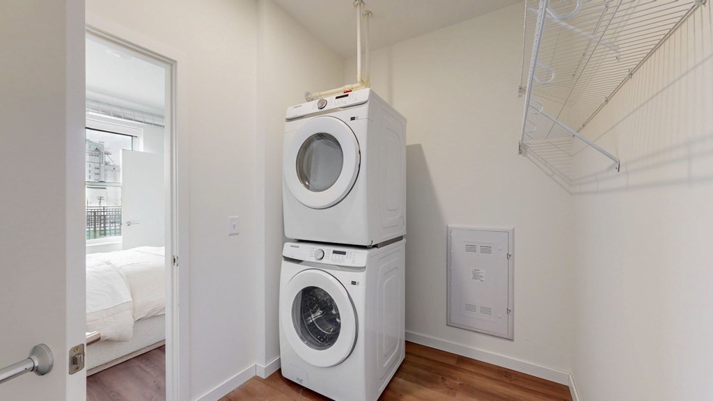 A white dryer and washer stacked on top of each other in a laundry room.