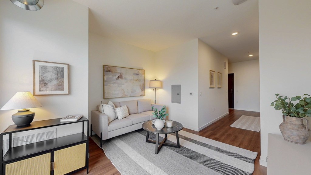 A living room with a white couch, a coffee table, and a lamp.
