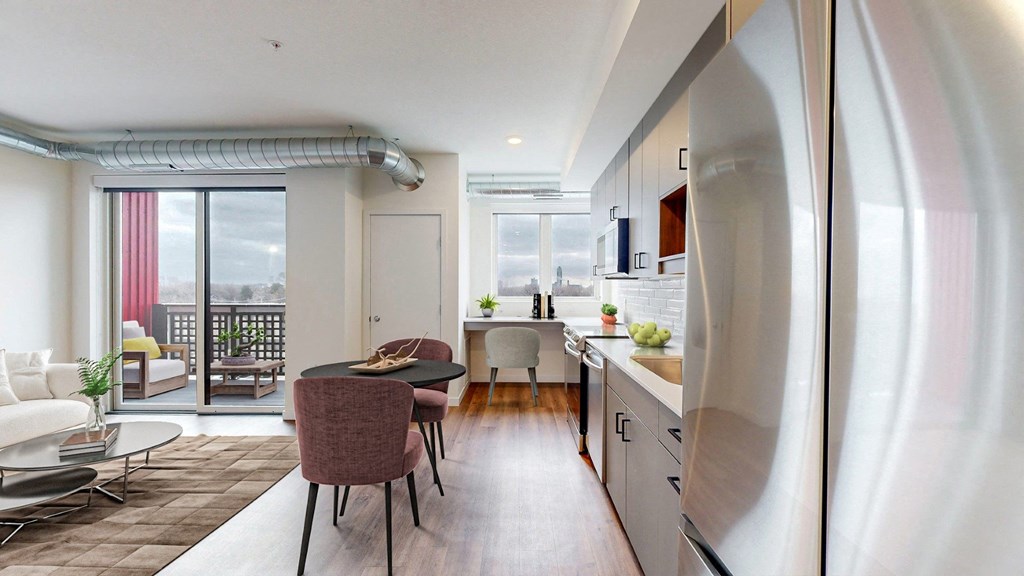 A modern kitchen with a dining table and chairs in the middle of the room.