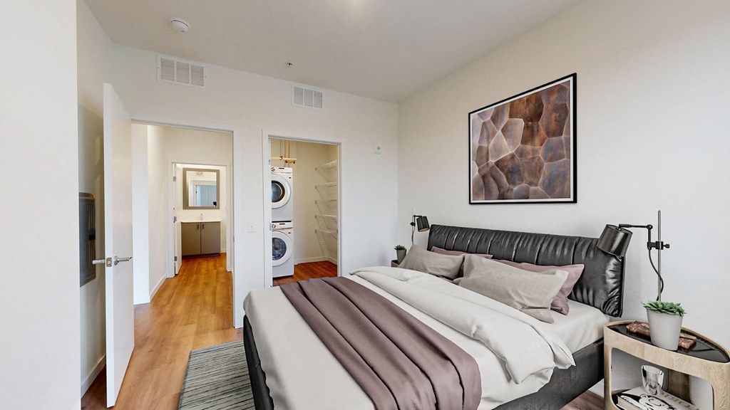 A bedroom with a bed, nightstand, and a painting on the wall.