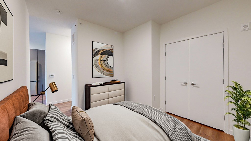 A bedroom with a bed, dresser, and wardrobe.