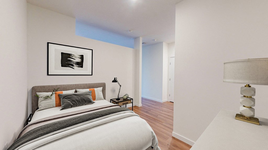 A bedroom with a large bed and a painting on the wall.