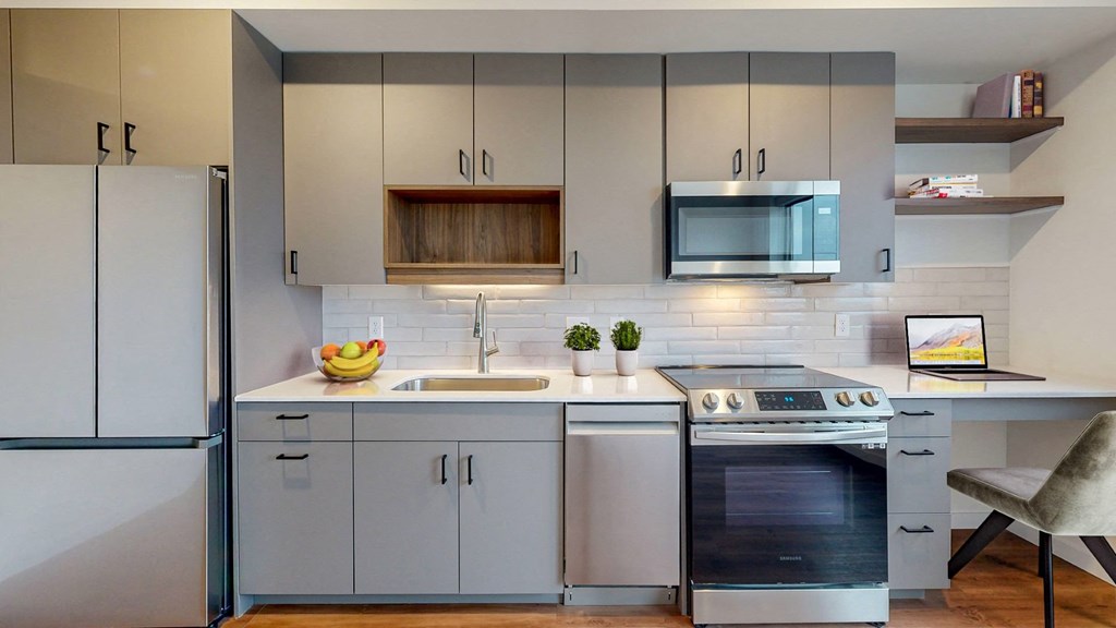 A modern kitchen with a stainless steel oven and a white fridge.