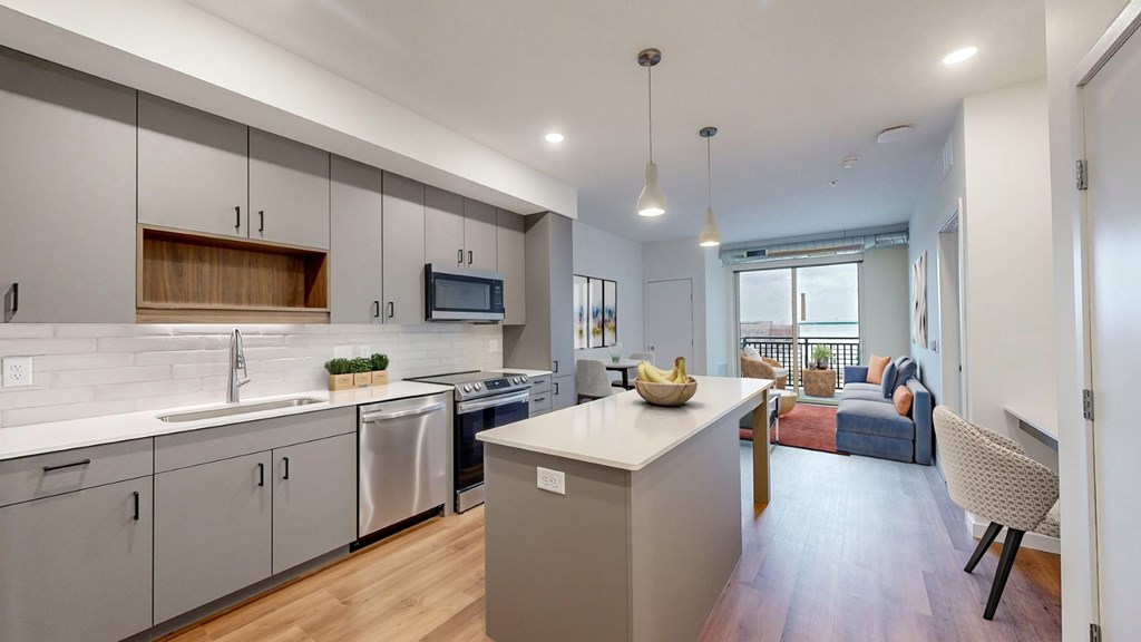 A modern kitchen with a dining area in the background.