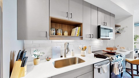 A modern kitchen with a white countertop and stainless steel appliances.
