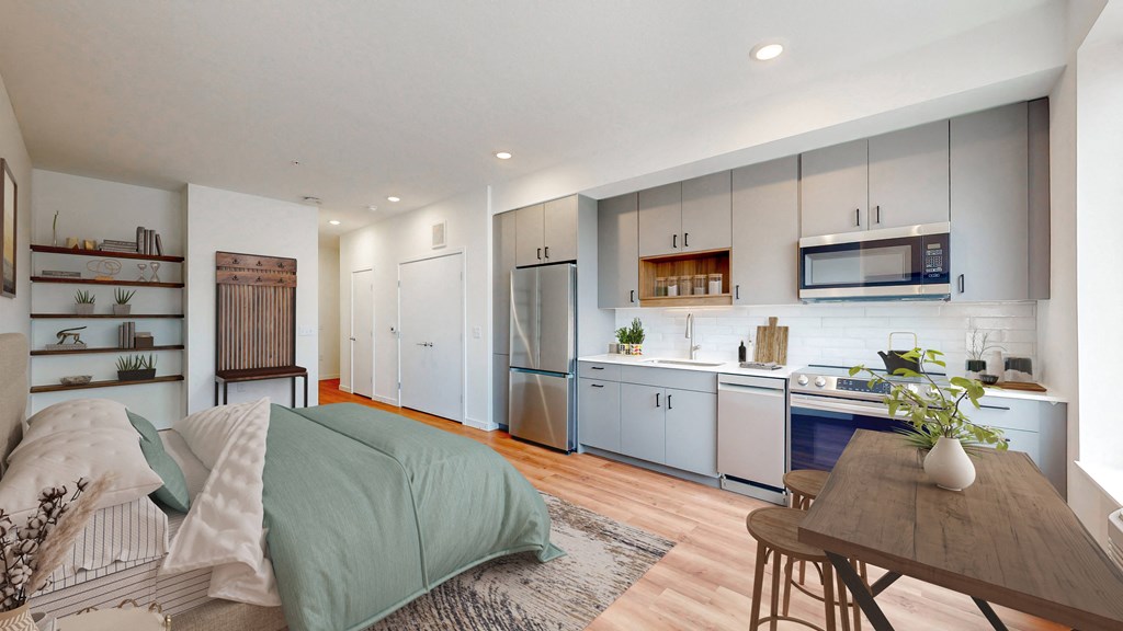 a bedroom with a bed and a kitchen with blue cabinets