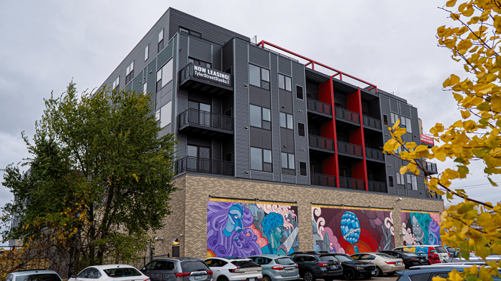 exterior image of an apartment building with a colorful mural on the side