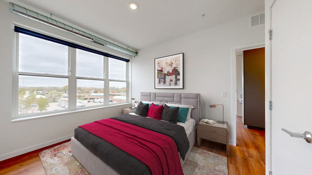 a bedroom with a bed and a large window