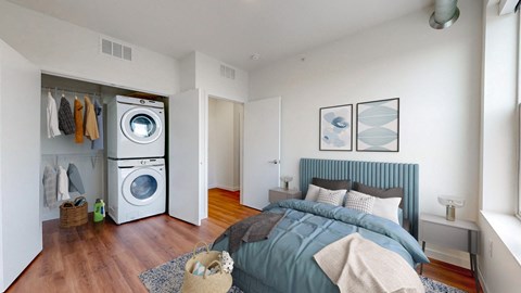 a bedroom with a bed and a washer and dryer