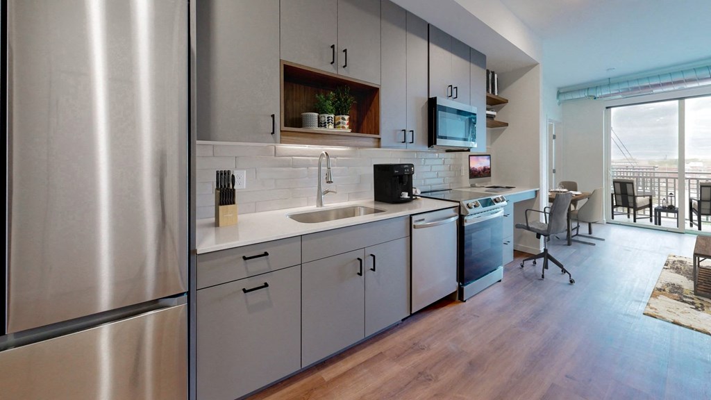 a kitchen with white cabinets and a stainless steel refrigerator
