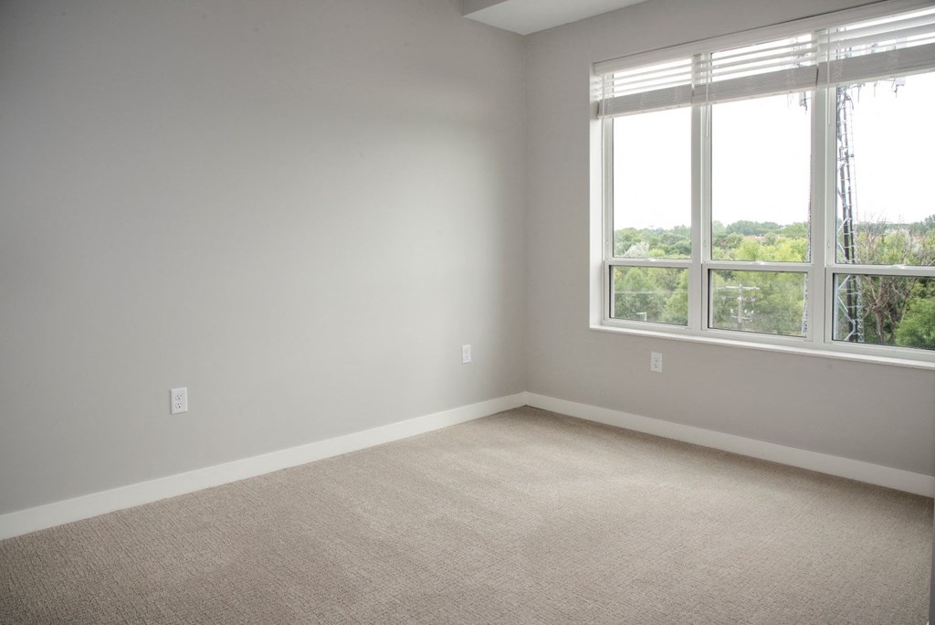 Spacious bedroom with large windows and walk-in closet at Urban Park I and II Apartments, St Louis Park, 55426