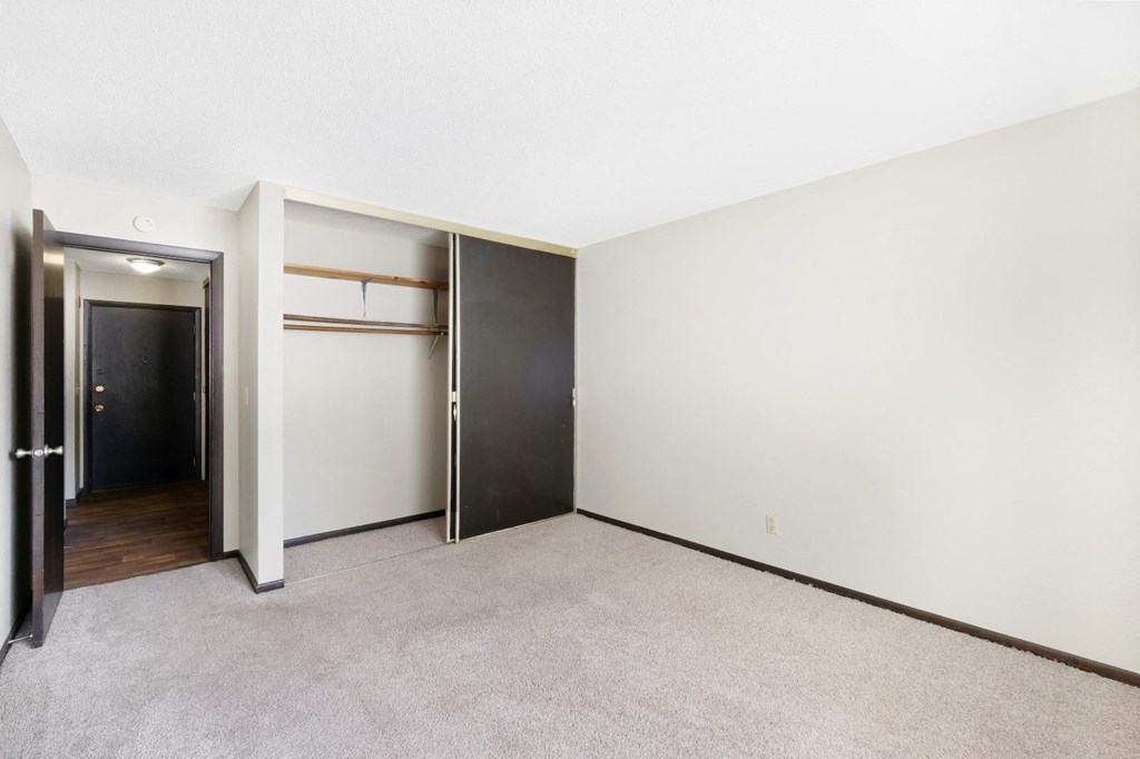 a bedroom with white walls and a gray carpet