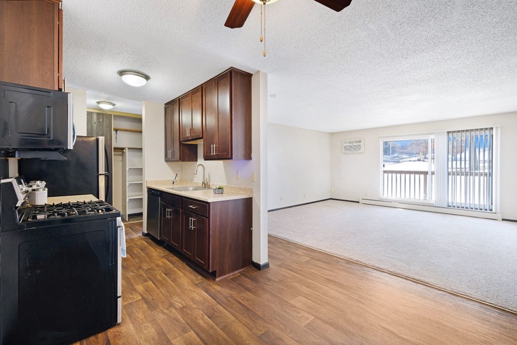 a kitchen and living room with wood floors and a large window