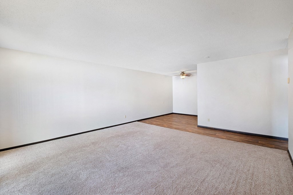 a bedroom with white walls and a wooden floor