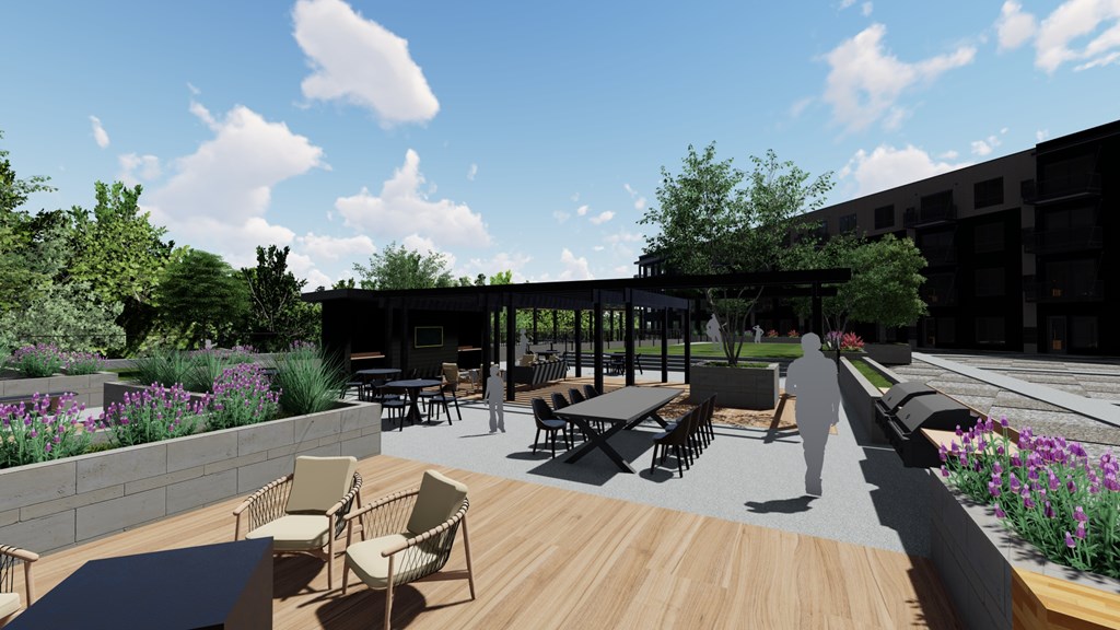 A patio with chairs and tables is surrounded by a wall of flowers. at Olivine Apartments, Minnesota