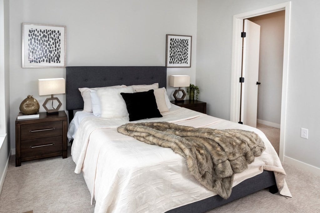 Bedroom with cozy bed and lamps at Volo at Texa Tonka Apartments , St Louis Park, Minnesota