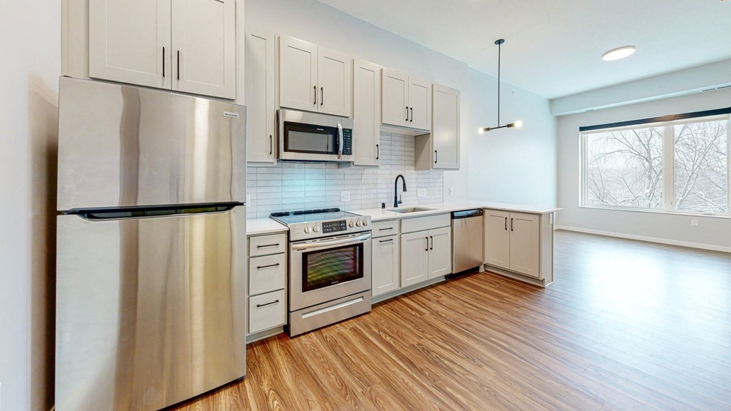 a kitchen with white cabinets and stainless steel appliances