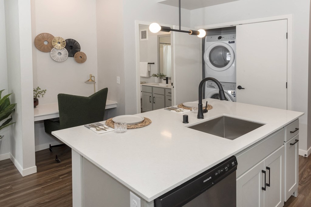 a kitchen with a sink and a washer and dryer in a 555 waverly