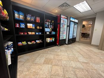 A room with a black shelf filled with snacks and drinks.