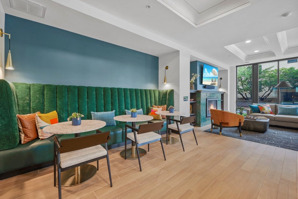 a lounge area with tables and chairs and a green couch